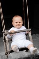happy baby boy on a swing