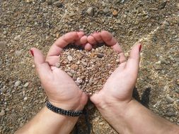 heart pebbles in hands