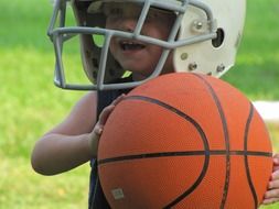 child with a helmet and a basketball ball