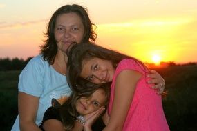 mother with daughters at sunset