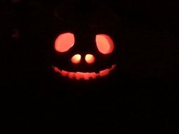 the candle glows inside the Halloween pumpkin in the dark