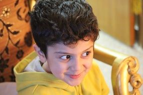 Smiling boy on a big chair