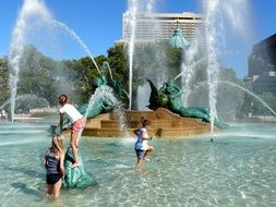 children playing in fountain at summer, usa, pennsylvania, philadelphia