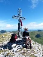 man near the cross on the mountain top