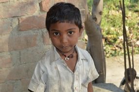 boy on the brick wall background in India