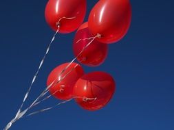 Five red balloons on the sky background