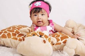 baby lies on a giraffe-shaped pillow