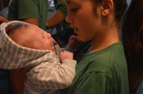 boy holds baby in his arms