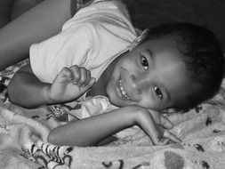 black and white photo of lying happy child