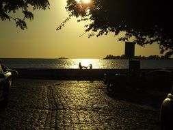 couple in love on the ocean promenade at sunset background