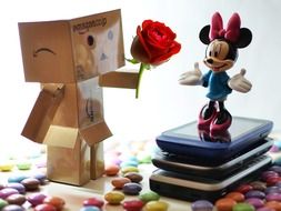 Danbo with a rose near the mini-mouse among sweets
