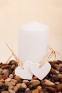 white candle and two white decorative hearts