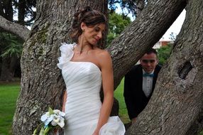 bride and groom near the tree