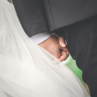 groom holds the hand of the bride at the wedding