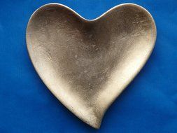 glossy silver heart at blue background