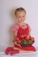 girl holding vegetables in her arms