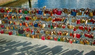 many colorful locks of love on the bridge on a sunny day