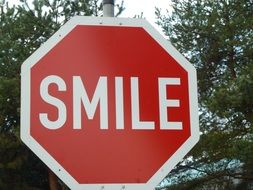 red sign with the word "smile"