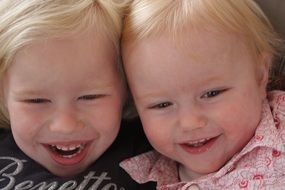 two blond children laugh