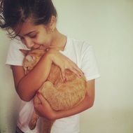 girl kissing red cat