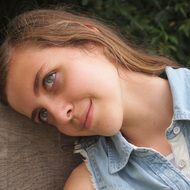 portrait of a pensive girl leaning against a tree