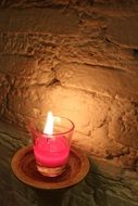 pink candle near the wall