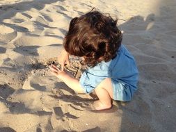 baby playing in the sand on the beach