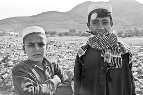 two afghan boys in black and white background