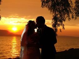 wedding couple kissing at sunset