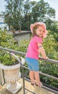 Pretty girl in Pink hat on metal fence
