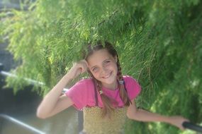 portrait of girl with pigtails on the bridge over the river