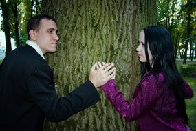 couple in love is holding on to a tree