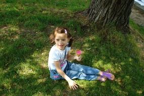 happy child sitting by the tree