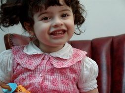 girl with curly hair and pink dress