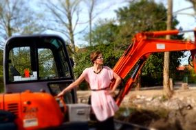 woman in pink dress on a excavator background