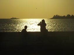 tourists are photographed on the beach at sunset