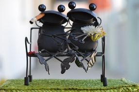 Decorative metal figure in the form of two frogs