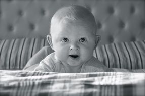 baby lying on bed portrait