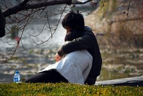couple under a tree in nature on a blurred background