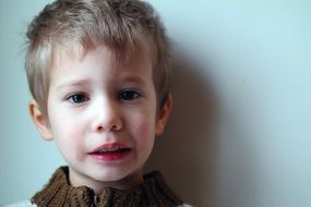 photo of boy against a white wall