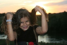 funny child girl with long hair at sunset