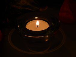 burning tealight candle in darkness