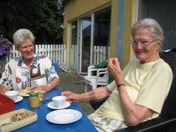 two senior women eating at table