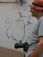 photographer and drawing of a cat on the wall