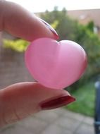 pink glass heart in hand