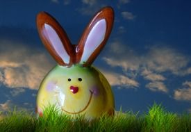 funny easter bunny figurine on green grass