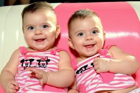 twins in striped clothes are smiling