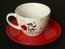 white cup on a red saucer
