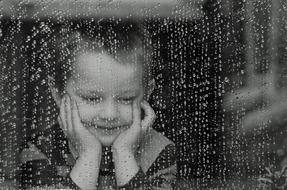 boy near the window during the rain