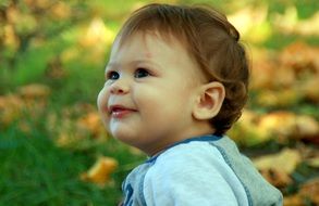 little boy smiling on the background of nature